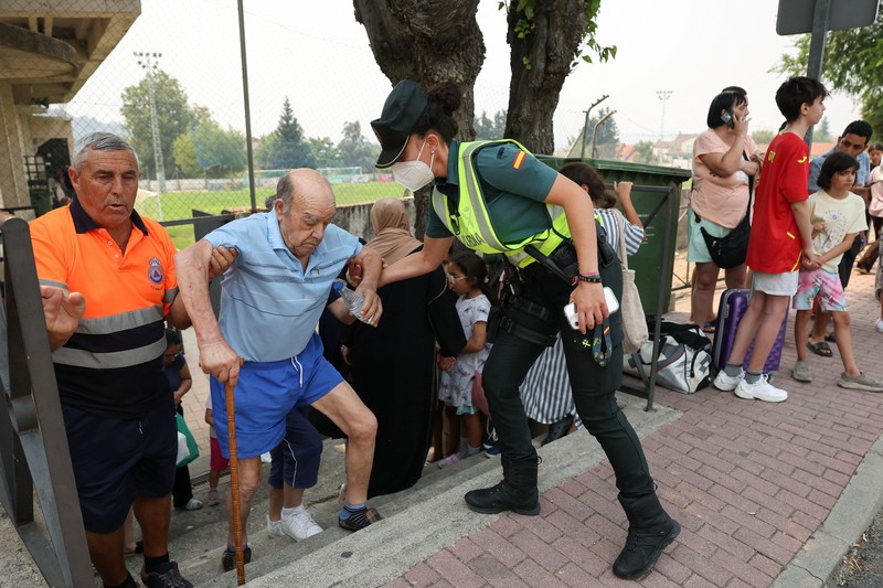 Seseorang berlari saat api menyebar di pegunungan Navaluenga, Avila, Spanyol, 23 Juli 2026. (REUTERS/Ana Beltran)