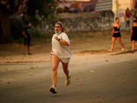 Seseorang berlari saat api menyebar di pegunungan Navaluenga, Avila, Spanyol, 23 Juli 2026. (REUTERS/Ana Beltran)