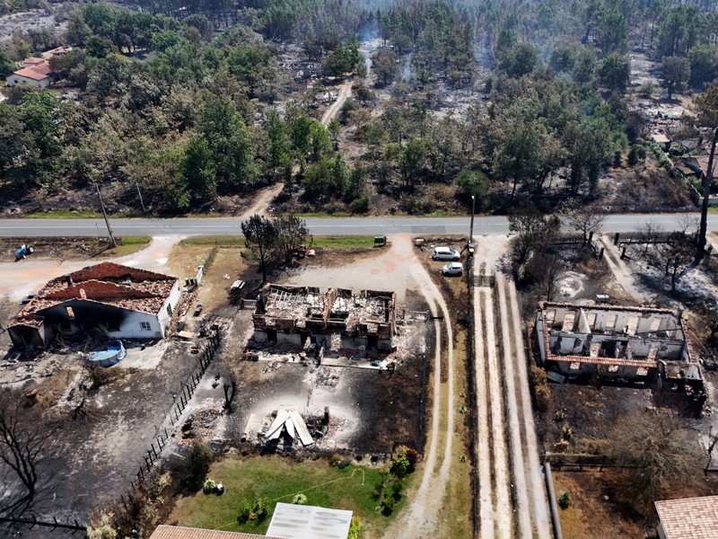 Foto udara menunjukkan rumah yang terbakar di daerah yang terkena dampak kebakaran hutan, di Le Porge, Gironde, di tengah kondisi kekeringan yang memburuk setelah gelombang panas dan kekurangan air di sebagian besar wilayah Prancis, Minggu (26/7/2026). (REUTERS/Manon Cruz)