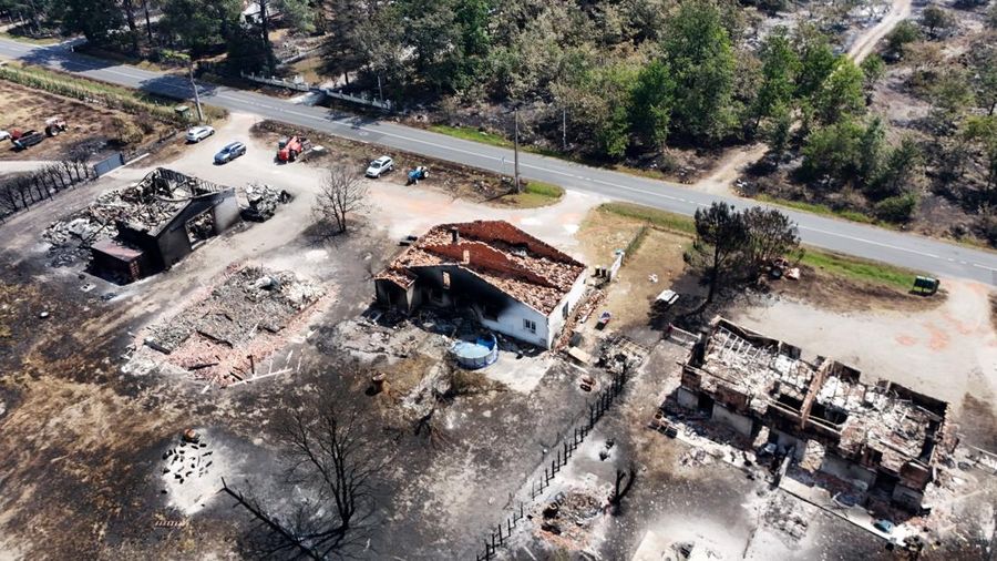 Foto udara menunjukkan rumah yang terbakar di daerah yang terkena dampak kebakaran hutan, di Le Porge, Gironde, di tengah kondisi kekeringan yang memburuk setelah gelombang panas dan kekurangan air di sebagian besar wilayah Prancis, Minggu (26/7/2026). (REUTERS/Manon Cruz)