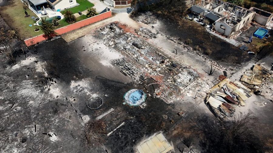 Foto udara menunjukkan rumah yang terbakar di daerah yang terkena dampak kebakaran hutan, di Le Porge, Gironde, di tengah kondisi kekeringan yang memburuk setelah gelombang panas dan kekurangan air di sebagian besar wilayah Prancis, Minggu (26/7/2026). (REUTERS/Manon Cruz)