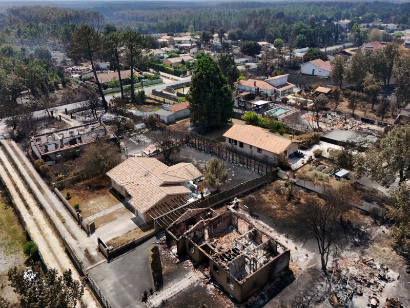 Foto udara menunjukkan rumah yang terbakar di daerah yang terkena dampak kebakaran hutan, di Le Porge, Gironde, di tengah kondisi kekeringan yang memburuk setelah gelombang panas dan kekurangan air di sebagian besar wilayah Prancis, Minggu (26/7/2026). (REUTERS/Manon Cruz)