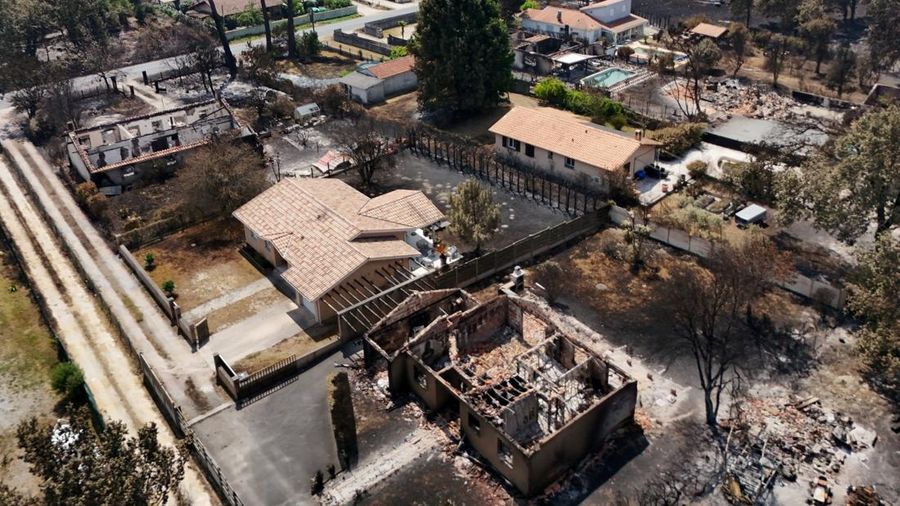 Foto udara menunjukkan rumah yang terbakar di daerah yang terkena dampak kebakaran hutan, di Le Porge, Gironde, di tengah kondisi kekeringan yang memburuk setelah gelombang panas dan kekurangan air di sebagian besar wilayah Prancis, Minggu (26/7/2026). (REUTERS/Manon Cruz)