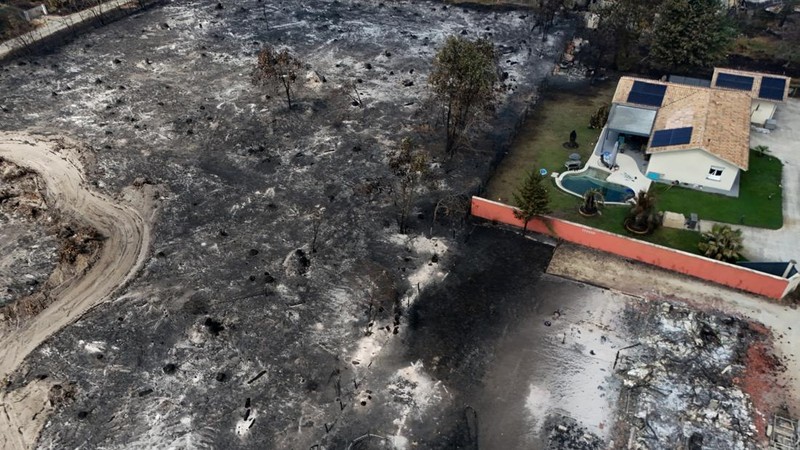 Foto udara menunjukkan rumah yang terbakar di daerah yang terkena dampak kebakaran hutan, di Le Porge, Gironde, di tengah kondisi kekeringan yang memburuk setelah gelombang panas dan kekurangan air di sebagian besar wilayah Prancis, Minggu (26/7/2026). (REUTERS/Manon Cruz)