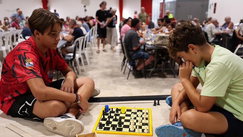 Anak-anak laki-laki bermain catur, sementara warga dari desa-desa yang dievakuasi berlindung di pusat olahraga di Moncofa, Castellon, Spanyol, 26 Juli 2026.