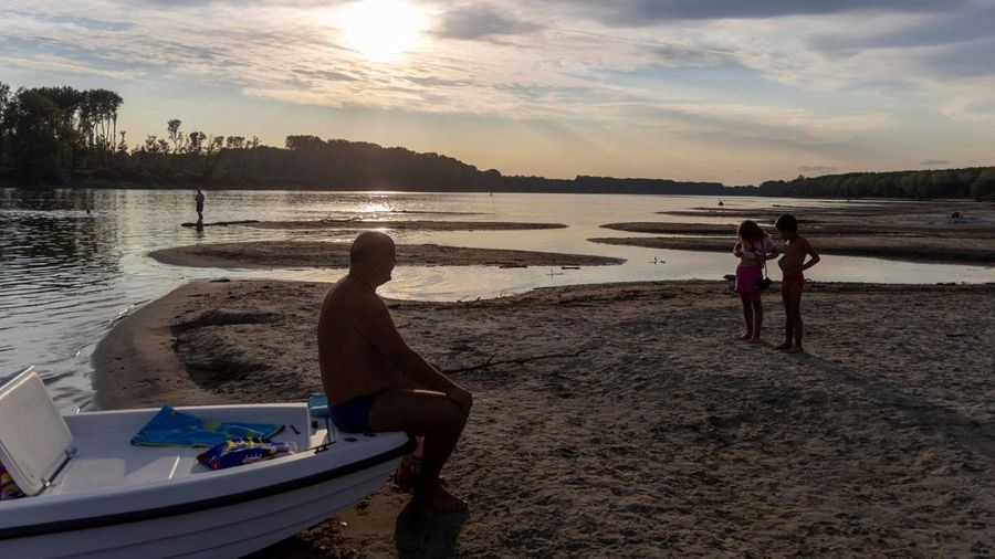 Orang-orang menikmati hari musim panas yang terik di tepian pasir yang baru muncul di Sungai Danube saat permukaan air menurun selama cuaca panas berkepanjangan dan kondisi kering, di Apatin, Serbia, 26 Juli 2026.