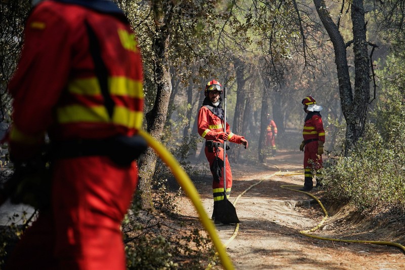 Warga dari desa-desa yang dievakuasi duduk untuk makan sambil berlindung di pusat olahraga di Moncofa, Castellon, Spanyol, 26 Juli 2026. (REUTERS/Eva Manez)