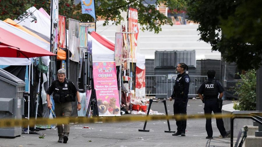 Para petugas polisi berkumpul di lokasi kejadian setelah Kepolisian Seattle menanggapi apa yang mereka gambarkan sebagai penembakan dengan "banyak" korban di Seattle Center, yang sedang menyelenggarakan festival makanan Bite of Seattle, di Seattle, W