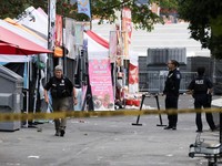 Para petugas polisi berkumpul di lokasi kejadian setelah Kepolisian Seattle menanggapi apa yang mereka gambarkan sebagai penembakan dengan "banyak" korban di Seattle Center, yang sedang menyelenggarakan festival makanan Bite of Seattle, di Seattle, W