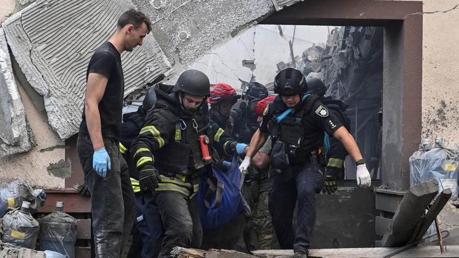 Tim penyelamat dan petugas polisi membawa jenazah seorang warga yang tewas di lokasi perusahaan penyedia air minum yang terkena serangan udara Rusia, di tengah serangan Rusia terhadap Ukraina, di Zaporizhzhia, Ukraina, 25 Juli 2026.