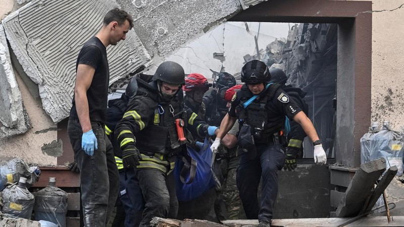 Tim penyelamat dan petugas polisi membawa jenazah seorang warga yang tewas di lokasi perusahaan penyedia air minum yang terkena serangan udara Rusia, di tengah serangan Rusia terhadap Ukraina, di Zaporizhzhia, Ukraina, 25 Juli 2026.