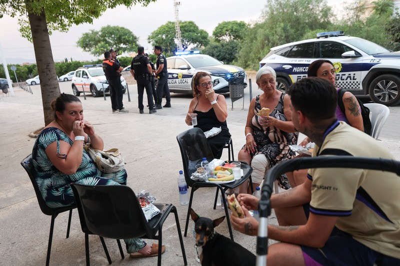 Warga dari desa-desa yang dievakuasi duduk untuk makan sambil berlindung di pusat olahraga di Moncofa, Castellon, Spanyol, 26 Juli 2026. (REUTERS/Eva Manez)