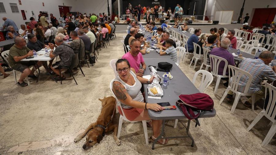 Warga dari desa-desa nan dievakuasi duduk untuk makan sembari berlindung di pusat olahraga di Moncofa, Castellon, Spanyol, 26 Juli 2026. (REUTERS/Eva Manez)