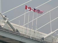 Bendera AS dan Kanada terlihat di titik tengah Jembatan Internasional Gordie Howe yang menghubungkan Windsor, Ontario ke Detroit, Michigan, AS, di Windsor, Ontario, Kanada, 27 Juli 2026. (REUTERS/Rebecca Cook)