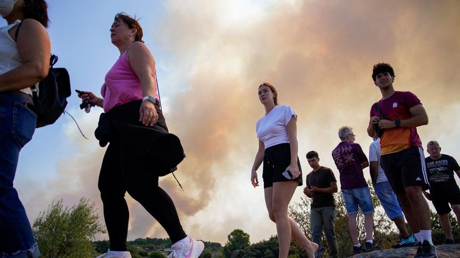 Orang-orang berkumpul saat asap mengepul dari kebakaran hutan di San Martin de Valdeiglesias, Komunitas Madrid, Spanyol, 26 Juli 2026.