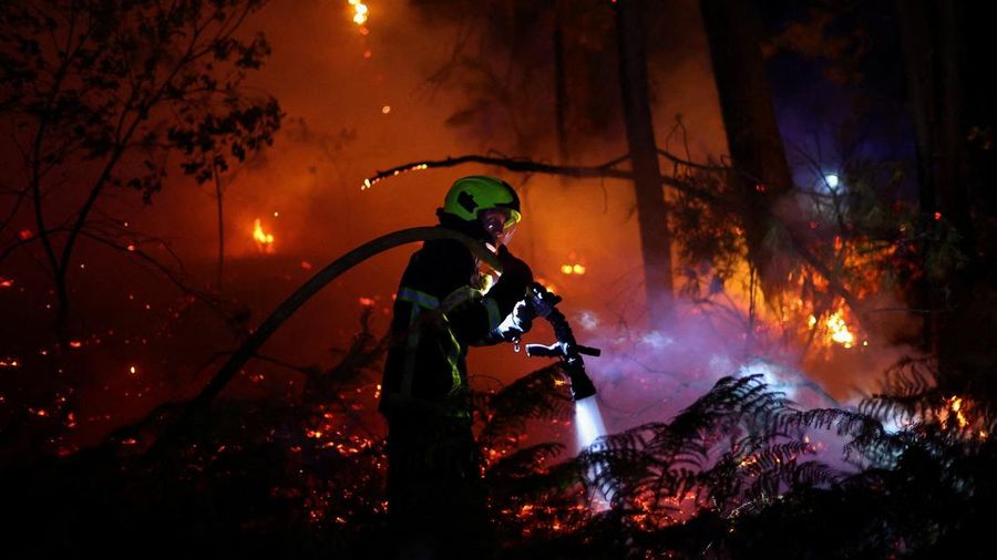 Seorang petugas pemadam kebakaran bekerja di lokasi kebakaran hutan di Andernos-les-Bains, departemen Gironde, di tengah kondisi kekeringan yang memburuk setelah gelombang panas dan kekurangan air di sebagian besar wilayah Prancis, 26 Juli 2026.