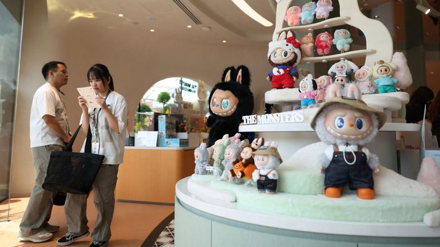 Guests wait next to a shelf of Labubu toys at Pop Mart's first international bakery during their media day at Resorts World Sentosa in Singapore July 29, 2026. REUTERS/Edgar Su