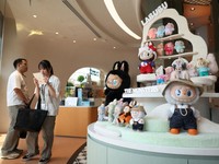 Guests wait next to a shelf of Labubu toys at Pop Mart's first international bakery during their media day at Resorts World Sentosa in Singapore July 29, 2026. REUTERS/Edgar Su