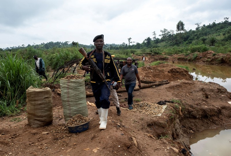 Charles Mambo, the supervisor at the Ceca-20 cemetery, flanked by Moise Mund'wa, the assistant warden of the cemetery, talks near graves during an interview with Reuters, as aid agencies intensify efforts to contain an Ebola outbreak caused by the Bundibugyo virus, in the Ebola hit Mungwalu, Djugu Territory of Ituri province, Democratic Republic of Congo, July 14, 2026. REUTERS/Gradel Muyisa Mumbere     TPX IMAGES OF THE DAY