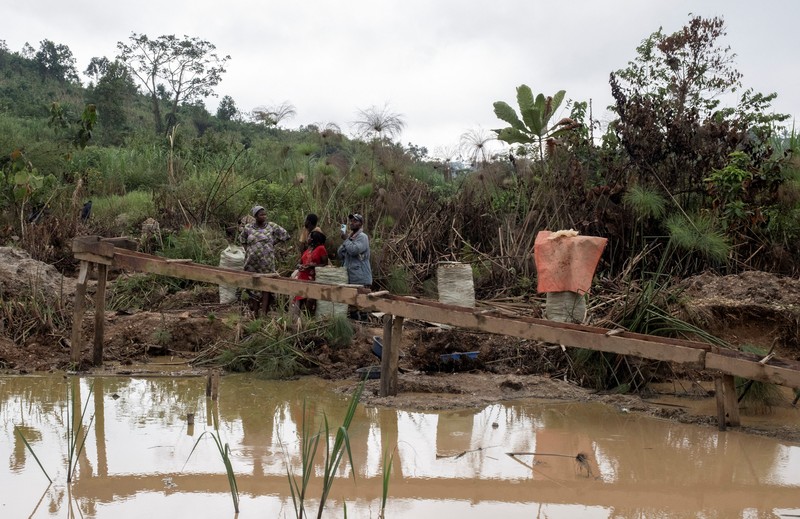 Charles Mambo, the supervisor at the Ceca-20 cemetery, flanked by Moise Mund'wa, the assistant warden of the cemetery, talks near graves during an interview with Reuters, as aid agencies intensify efforts to contain an Ebola outbreak caused by the Bundibugyo virus, in the Ebola hit Mungwalu, Djugu Territory of Ituri province, Democratic Republic of Congo, July 14, 2026. REUTERS/Gradel Muyisa Mumbere     TPX IMAGES OF THE DAY
