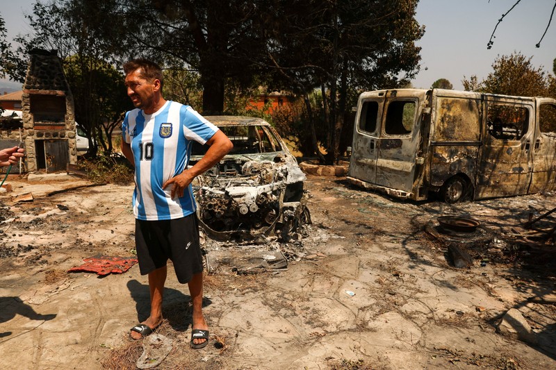 Luis Gonzalez berdiri di tengah-tengah properti yang terbakar dan rusak di desa El Tiemblo, saat kebakaran hutan terus melanda provinsi Avila dan Madrid, Spanyol, 28 Juli 2026. (REUTERS/Violeta Santos Moura)