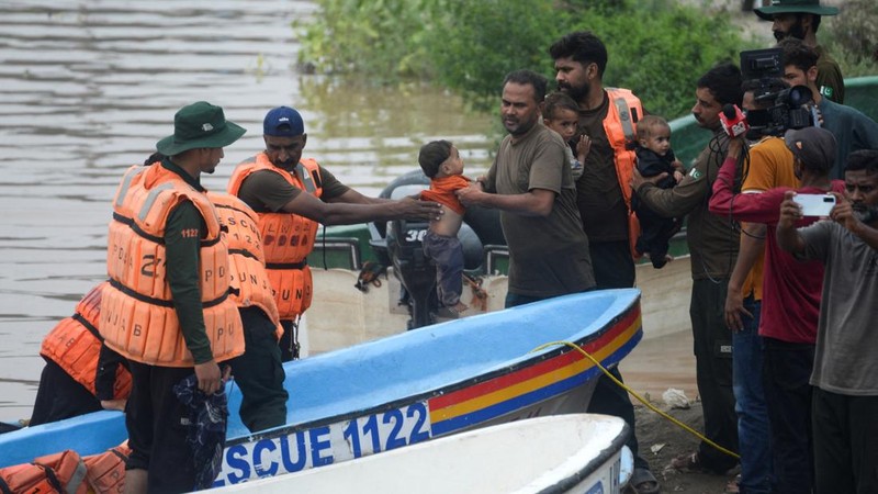 Para petugas Rescue 1122 memindahkan anak-anak setelah mereka, bersama keluarga mereka, dievakuasi dari daerah yang terendam banjir akibat hujan monsun, di Ferozwala, Pakistan, 28 Juli 2026.