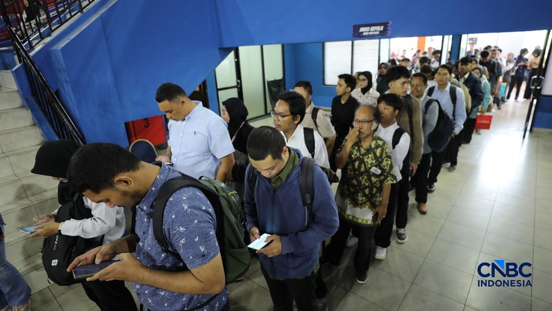 Pencari kerja mencari informasi lowongan pekerjaan pada kegiatan Job Fair yang digelar Pemkot Jakarta Timur di GOR Ciracas, Jakarta, Rabu (29/7/2026). (CNBC Indonesia/Tri Susilo)