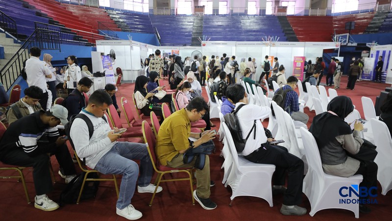 Pencari kerja mencari informasi lowongan pekerjaan pada kegiatan Job Fair yang digelar Pemkot Jakarta Timur di GOR Ciracas, Jakarta, Rabu (29/7/2026). (CNBC Indonesia/Tri Susilo)