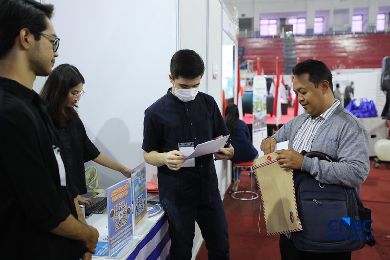 Pencari kerja mencari informasi lowongan pekerjaan pada kegiatan Job Fair yang digelar Pemkot Jakarta Timur di GOR Ciracas, Jakarta, Rabu (29/7/2026). (CNBC Indonesia/Tri Susilo)