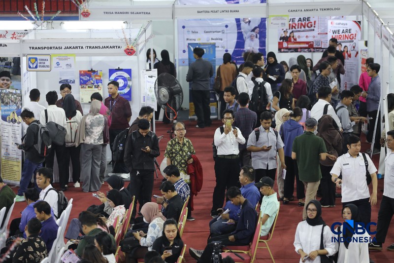 Pencari kerja mencari informasi lowongan pekerjaan pada kegiatan Job Fair yang digelar Pemkot Jakarta Timur di GOR Ciracas, Jakarta, Rabu (29/7/2026). (CNBC Indonesia/Tri Susilo)