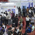 Pencari kerja mencari informasi lowongan pekerjaan pada kegiatan Job Fair yang digelar Pemkot Jakarta Timur di GOR Ciracas, Jakarta, Rabu (29/7/2026). (CNBC Indonesia/Tri Susilo)