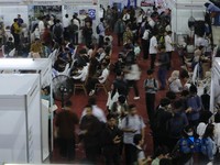 Pencari kerja mencari informasi lowongan pekerjaan pada kegiatan Job Fair yang digelar Pemkot Jakarta Timur di GOR Ciracas, Jakarta, Rabu (29/7/2026). (CNBC Indonesia/Tri Susilo)