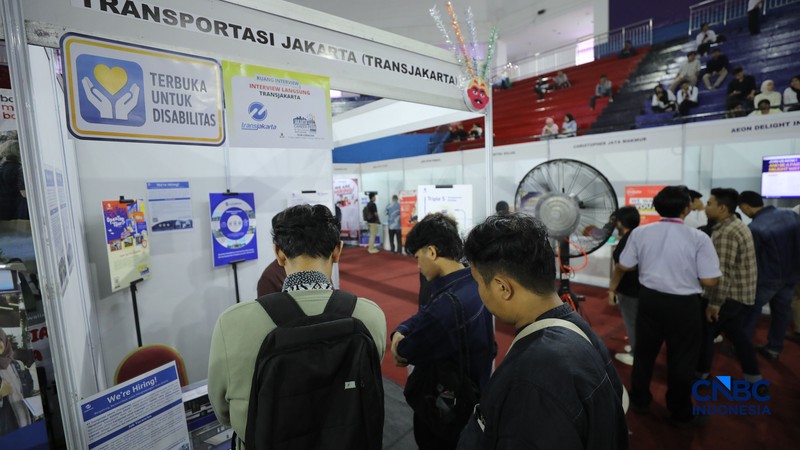 Pencari kerja mencari informasi lowongan pekerjaan pada kegiatan Job Fair yang digelar Pemkot Jakarta Timur di GOR Ciracas, Jakarta, Rabu (29/7/2026). (CNBC Indonesia/Tri Susilo)