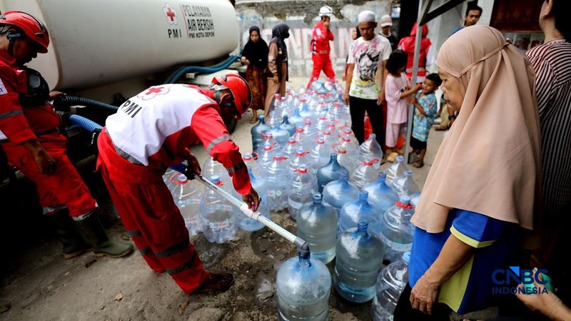 Petugas Palang Merah Indonesia (PMI) mendistribusikan air bersih kepada 78 kepala keluarga di RW 08, Cipayung Jaya, Kota Depok, Jawa Barat, Rabu (29/7/2026). (CNBC Indonesia/Tri Susilo)