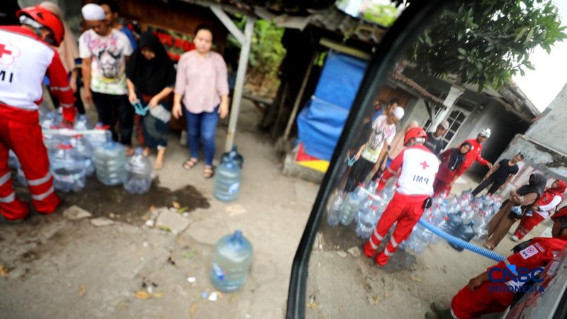 Petugas Palang Merah Indonesia (PMI) mendistribusikan air bersih kepada 78 kepala keluarga di RW 08, Cipayung Jaya, Kota Depok, Jawa Barat, Rabu (29/7/2026). (CNBC Indonesia/Tri Susilo)