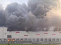 A woman looks on as smoke billows from a Wildberries warehouse after a fire broke out at the facility, in Ryazan region, Russia, July 29, 2026, in this still image obtained from a video. SOCIAL MEDIA/via REUTERS  THIS IMAGE HAS BEEN SUPPLIED BY A THI