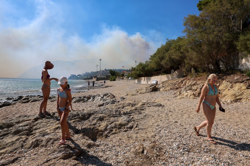 Para wisatawan bersiap untuk diangkut dengan bus dari kota Moires saat kebakaran hutan melanda pulau Kreta, Yunani, 30 Juli 2026. (REUTERS/Stringer)