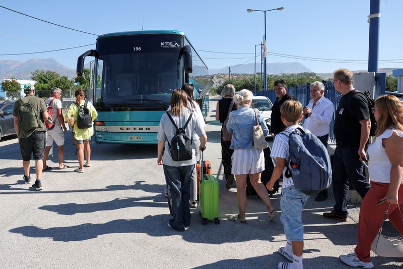 Para wisatawan bersiap untuk diangkut dengan bus dari kota Moires saat kebakaran hutan melanda pulau Kreta, Yunani, 30 Juli 2026. (REUTERS/Stringer)