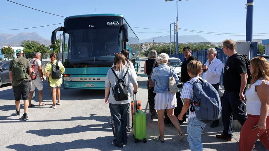 Para wisatawan bersiap untuk diangkut dengan bus dari kota Moires saat kebakaran hutan melanda pulau Kreta, Yunani, 30 Juli 2026. (REUTERS/Stringer)