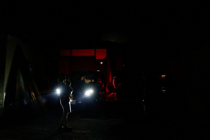 Sebuah keluarga menggunakan lampu dari mobil dan generator pribadi mereka, setelah gempa bumi di Uki, Jepang, 30 Juli 2026. (REUTERS/Kim Kyung-Hoon)