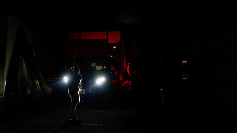 Sebuah keluarga menggunakan lampu dari mobil dan generator pribadi mereka, setelah gempa bumi di Uki, Jepang, 30 Juli 2026. (REUTERS/Kim Kyung-Hoon)