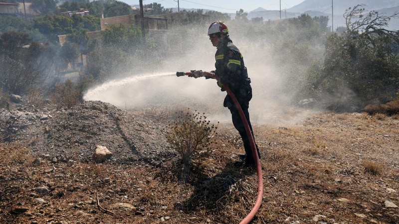 Seorang petugas pemadam kebakaran berupaya memadamkan kebakaran hutan yang terjadi di dekat pantai Triopetra di pulau Kreta, Yunani, 30 Juli 2026.