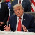 U.S. President Donald Trump speaks as he sits behind an airport model as he makes an announcement about a $22.5 billion renovation of Washington Dulles International Airport with U.S. Secretary of Transportation Sean Duffy (not pictured) in the Oval