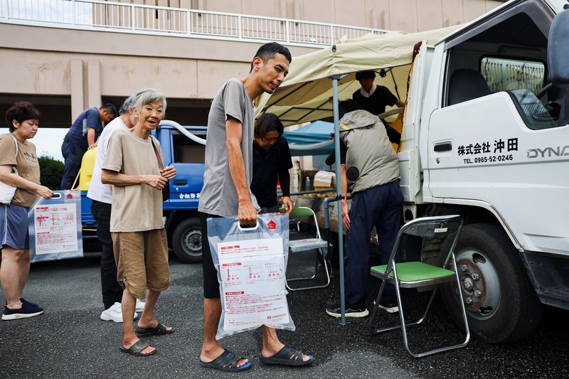 Sebuah keluarga menggunakan lampu dari mobil dan generator pribadi mereka, setelah gempa bumi di Uki, Jepang, 30 Juli 2026. (REUTERS/Kim Kyung-Hoon)