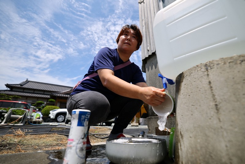 Sebuah keluarga menggunakan lampu dari mobil dan generator pribadi mereka, setelah gempa bumi di Uki, Jepang, 30 Juli 2026. (REUTERS/Kim Kyung-Hoon)
