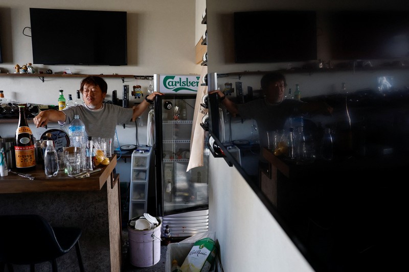 Sebuah keluarga menggunakan lampu dari mobil dan generator pribadi mereka, setelah gempa bumi di Uki, Jepang, 30 Juli 2026. (REUTERS/Kim Kyung-Hoon)