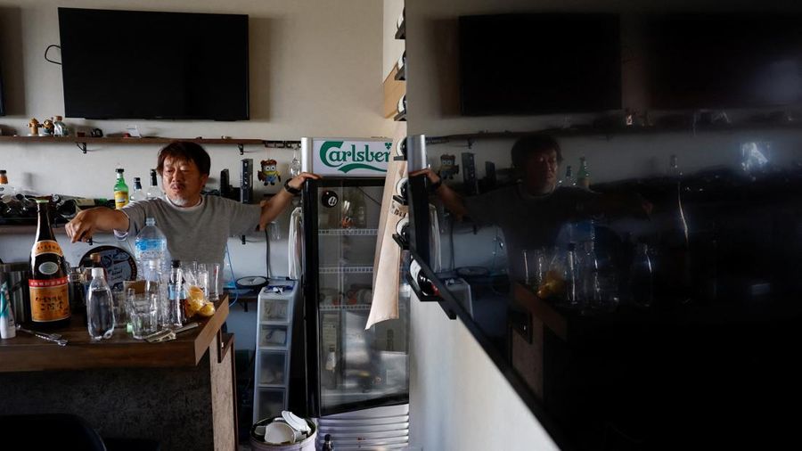 Yusuke Hashimoto, 50 tahun, pemilik Sport Bar 44, membersihkan barang-barang yang rusak dan berserakan di barnya setelah gempa bumi, sementara pemadaman listrik dan air masih berlanjut di Uki, Jepang, 30 Juli 2026.