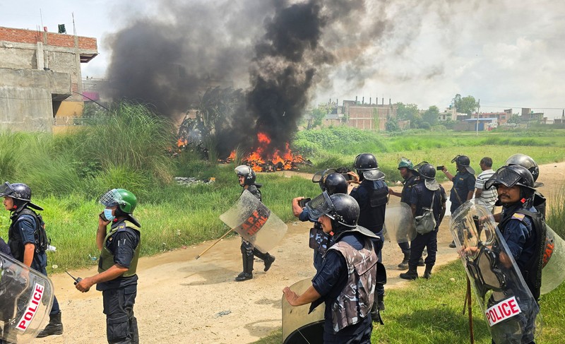 Anggota Pasukan Polisi Bersenjata (APF) mengejar demonstran selama protes menyusul bentrokan antara dua komunitas di Siraha, Nepal, 30 Juli 2026. (REUTERS/Stringer)