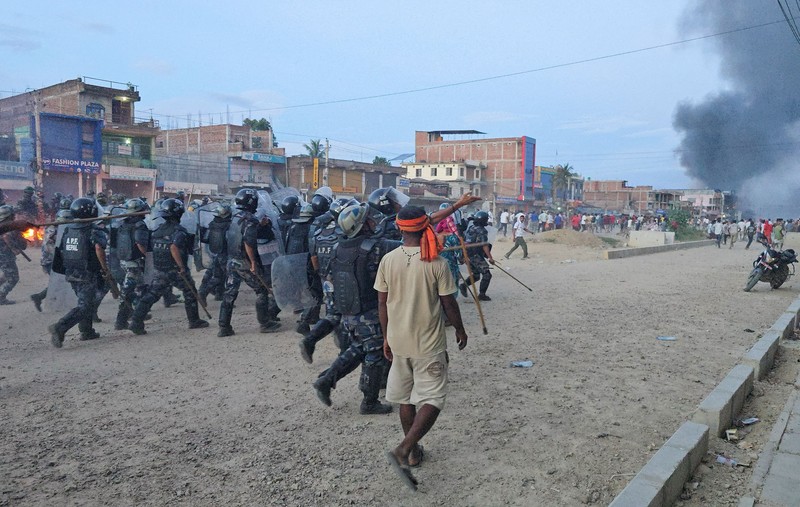 Anggota Pasukan Polisi Bersenjata (APF) mengejar demonstran selama protes menyusul bentrokan antara dua komunitas di Siraha, Nepal, 30 Juli 2026. (REUTERS/Stringer)