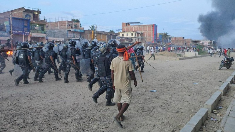 Anggota Pasukan Polisi Bersenjata (APF) mengejar demonstran selama protes menyusul bentrokan antara dua komunitas di Siraha, Nepal, 30 Juli 2026. (REUTERS/Stringer)
